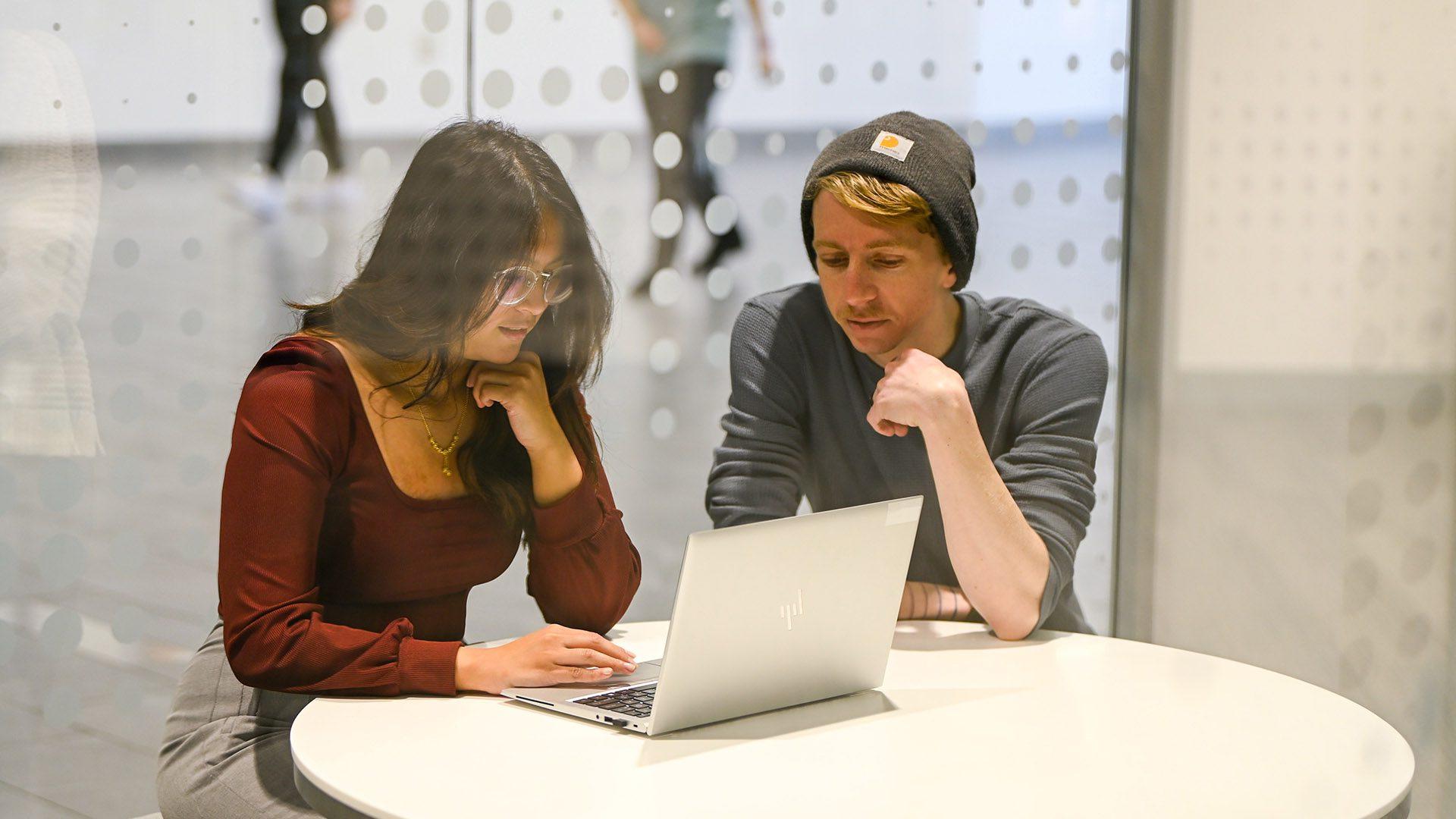 Interns working on laptop en español: Pasantes trabajando en la computadora portátil